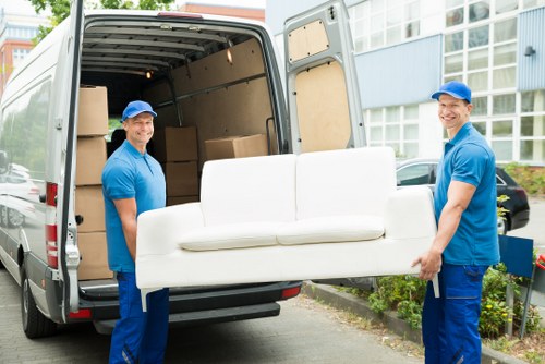 Furniture removal team working in Waterloo with a sofa in a residential property